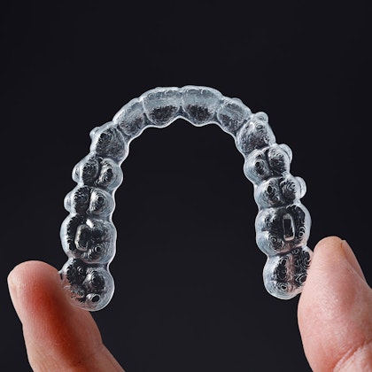 Hand holding invisalign