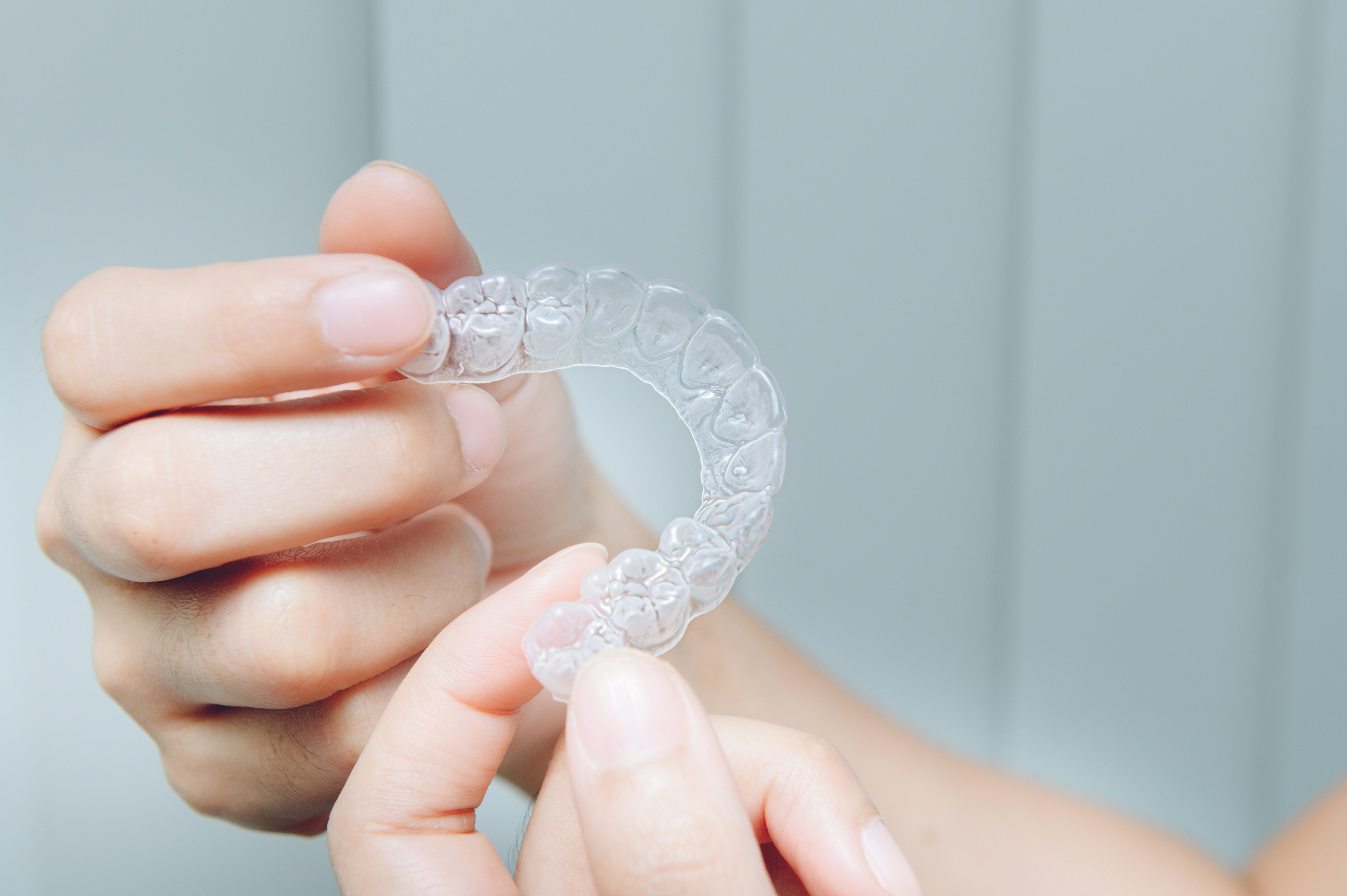 person holding Invisalign aligner